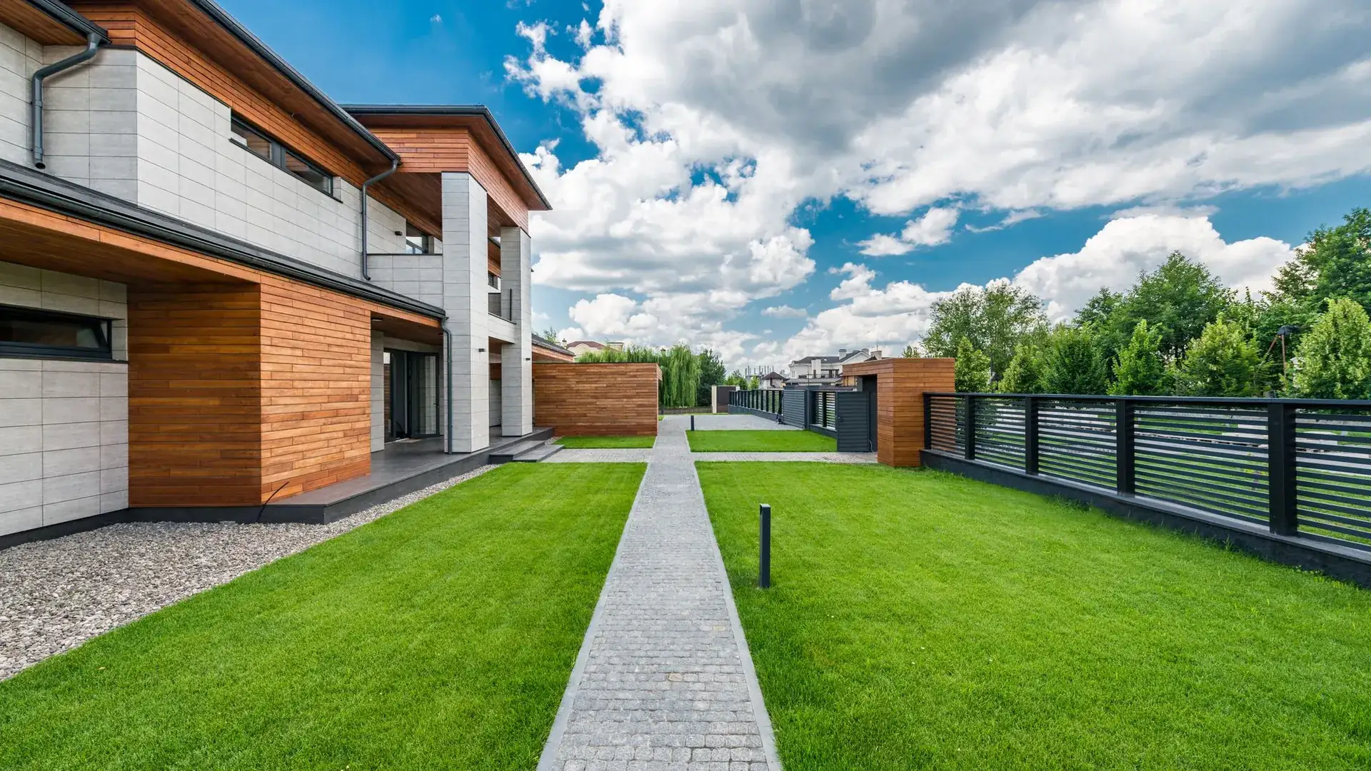 Casa moderna con jardín verde y camino de piedra