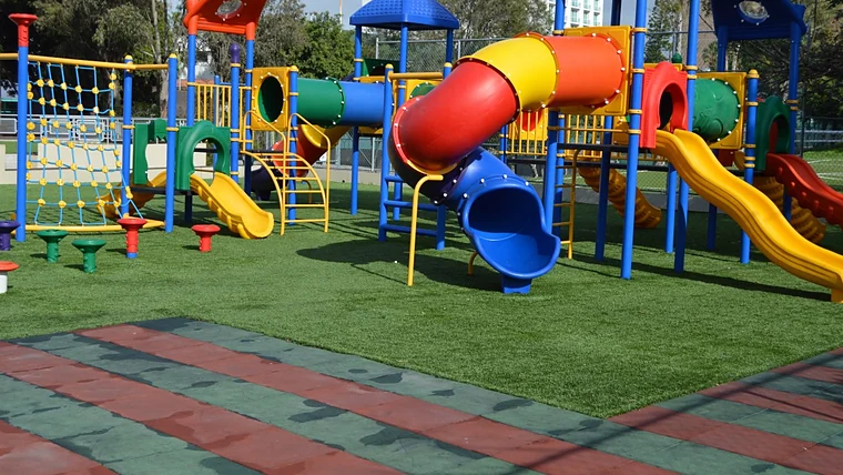 Área de juegos infantiles sobre pasto sintético