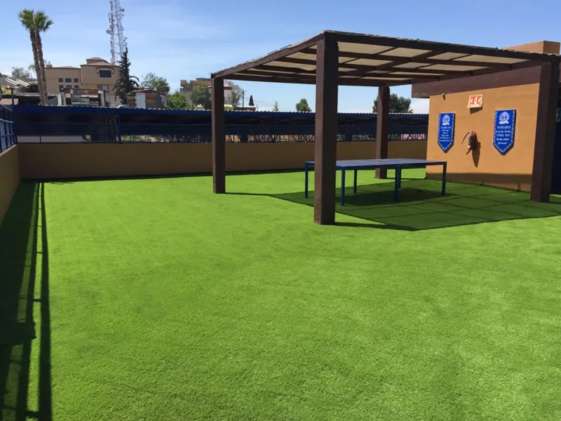 Azotea amplia con pérgola de madera y pasto sintético