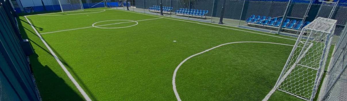 Cancha de fútbol con pasto sintético y gradas