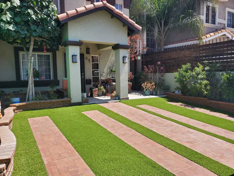 Jardín con franjas de pasto sintético separadas por bandas de piso