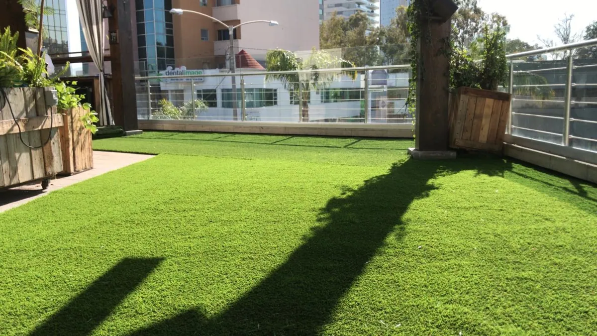Área verde común de un edificio con pasto sintético