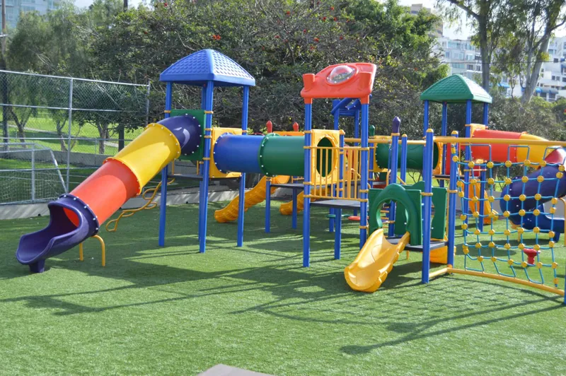 Juegos infantiles instalados sobre pasto sintético