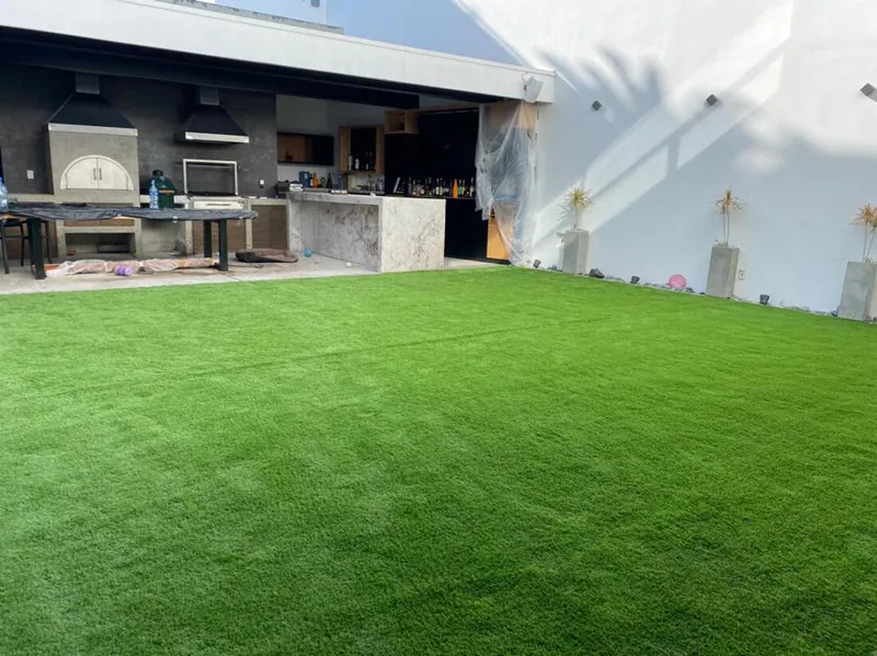 Terraza con cocina exterior y piso de pasto sintético