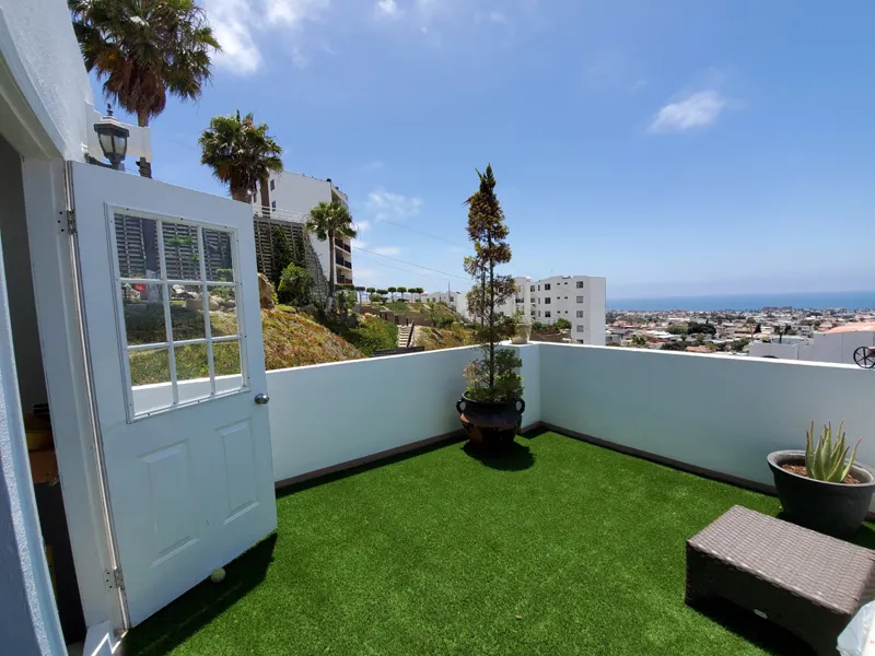 Terraza en azotea con pasto sintético y vista a la ciudad