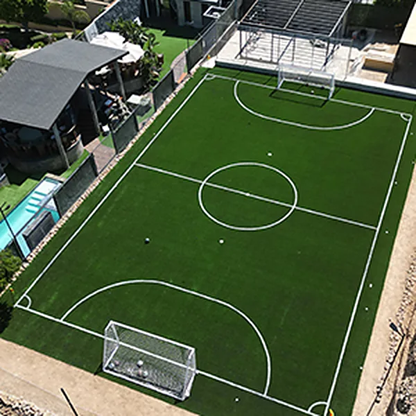 Cancha de fútbol 7 de pasto sintético vista desde arriba, con portería y líneas blancas