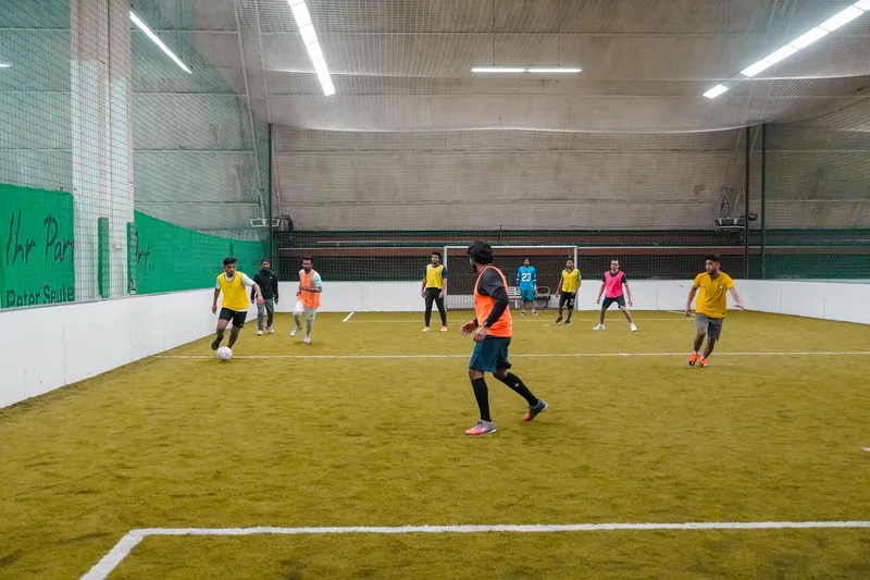 Cancha techada de fútbol con pasto sintético y paredes alrededor