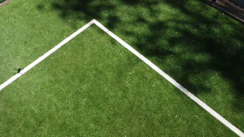 Esquina de líneas blancas insertadas en pasto sintético verde